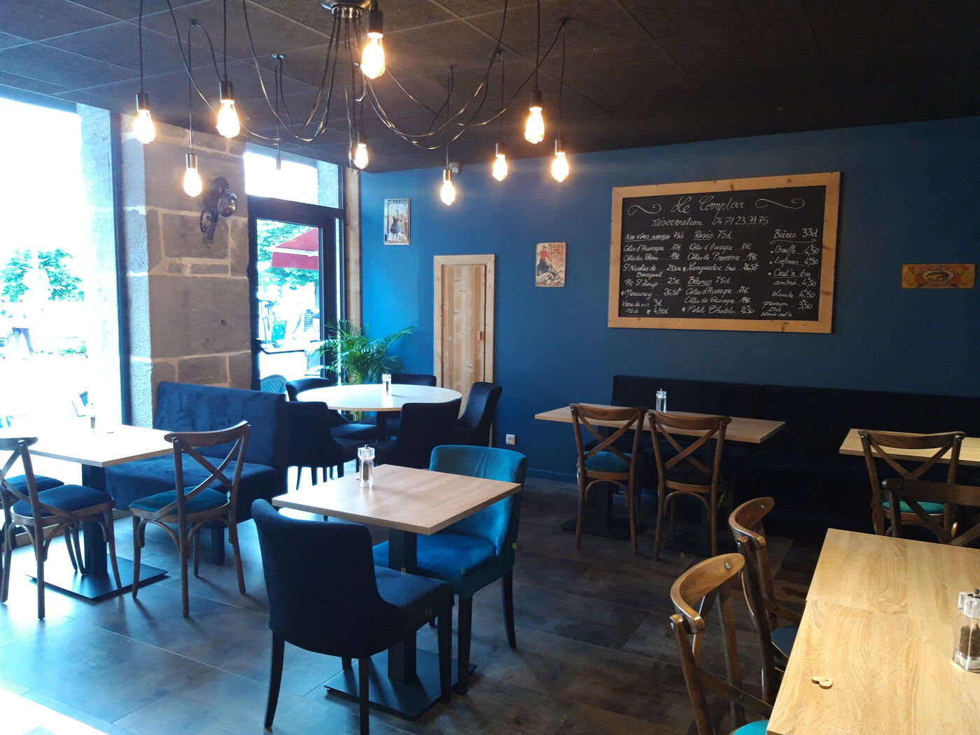 La salle bleue du Comptoir, tables bois et ampoules suspendues